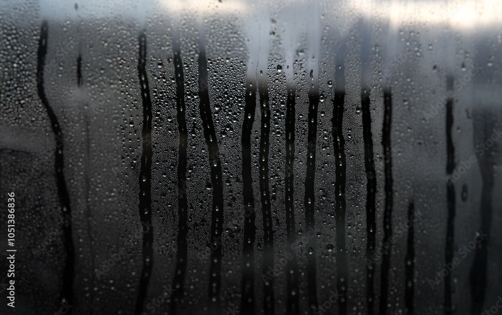 Aufkleber A window pane covered in condensation with streaks of water running down the surface.
