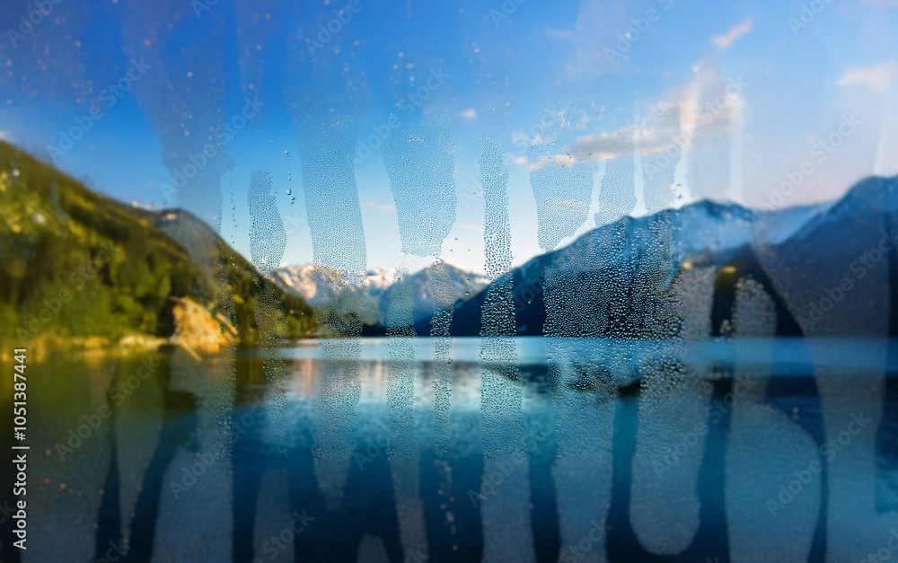 Poster A view of a mountain lake through a window covered in condensation.