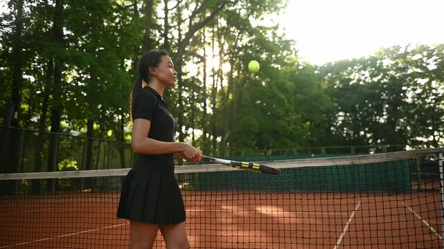 A tennis player plays sports on a tennis court . The athlete trains in tennis. An African girl plays tennis. 