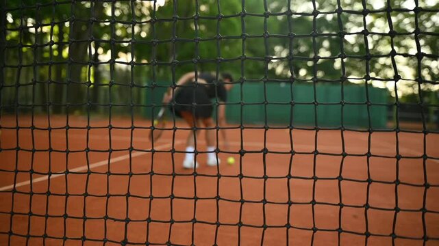 A tennis player plays sports on a tennis court . The athlete trains in tennis. An African girl plays tennis. 