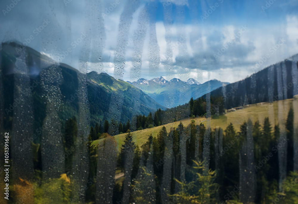 Poster A view of a mountain range through a rain-streaked window.