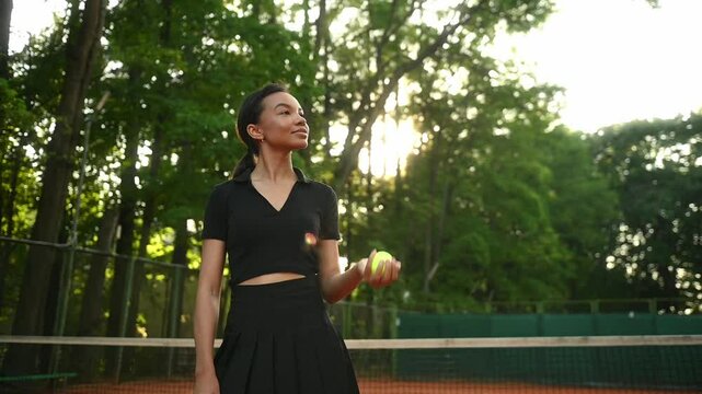 A tennis player plays sports on a tennis court . The athlete trains in tennis. An African girl plays tennis. 