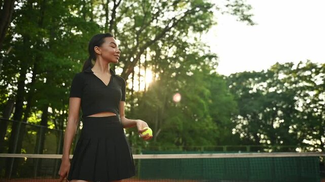 A tennis player plays sports on a tennis court . The athlete trains in tennis. An African girl plays tennis. 