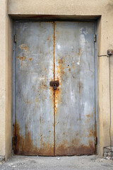 Iron metal door with a lock, old and rusty