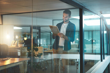 Fototapeta premium Man, tablet and reading with thinking, startup and smile with review, editing and overtime at office. Person, digital touchscreen and ideas with application, contact and night at creative agency