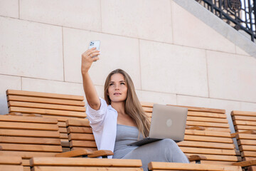 Woman, Selfie, Laptop. Taking a selfie on bench with laptop.
