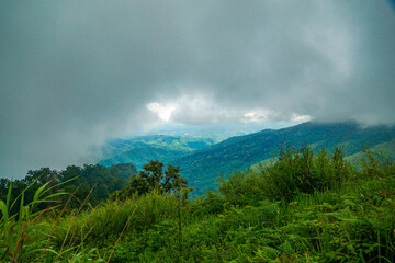 A scenic view of lush green hills beneath a cloudy sky.