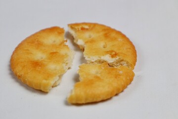 Round salty cracked biscuit isolated on white