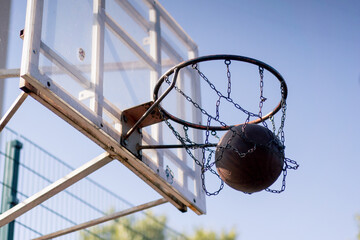 a sports ground basketball field shot from below basketball hoop with chains hitting the target...