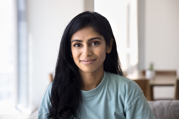 Positive beautiful relaxed Indian girl home head shot. Cheerful attractive young woman in casual...
