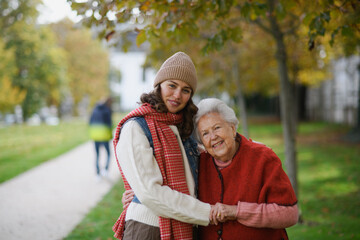 Portrait of a granddaughter on an autumn walk in the park with her grandmother.
