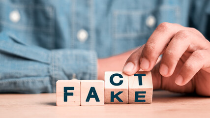 Flipping Wooden cube block for change fake to fact , news and social media concept.