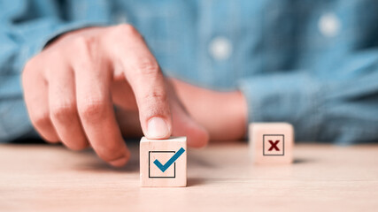 Businessman select blue correct sign mark between Red Cross mark which print screen on wooden for...