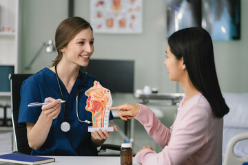 Female doctor and patient are talking and consulting at the table in a medical clinic or hospital health service.