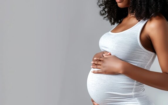 Young black pregnant woman in white top holding hands on her big belly, touching tummy. Curly black hair, brunette lady expecting a baby, side view. Second trimester pregnancy banner, AI generated