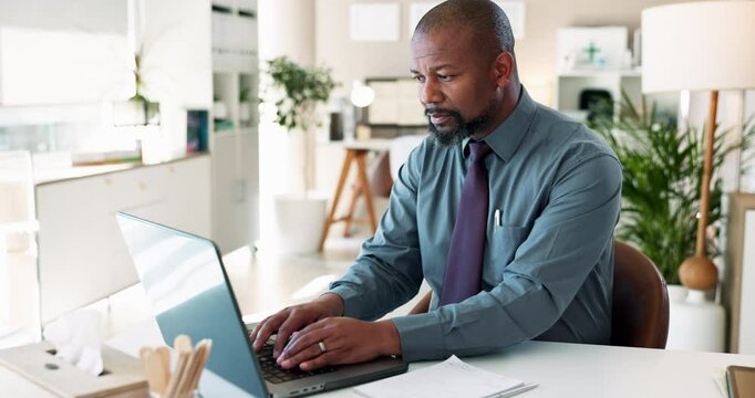 Black man, typing and laptop with documents for report, finance or accounting at office desk. African, businessman or accountant with computer or paperwork for audit, financial planning or budget