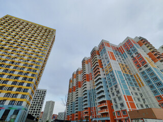 A pastel-colored high-rise residential building with curved balconies and windows, set above a...