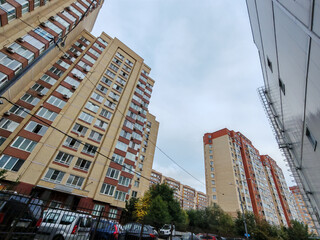 A pastel-colored high-rise residential building with curved balconies and windows, set above a...