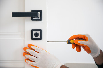 Man fixing the door handle with screwdriver