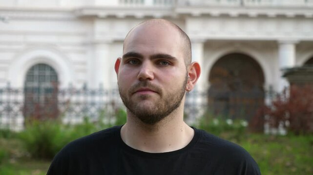 A close-up shot of a young man's face as he shakes his head in disagreement. His expression reflects certainty and a firm stance.
