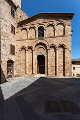 The facade of a Romanesque church in a small Italian town.