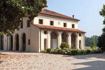 View of an Italian villa and the road leading to it through the trees.