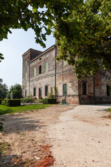 View of an Italian villa and the road leading to it through the trees.