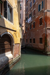 View of a Venetian canal. Two old Venetian houses standing on the canal.