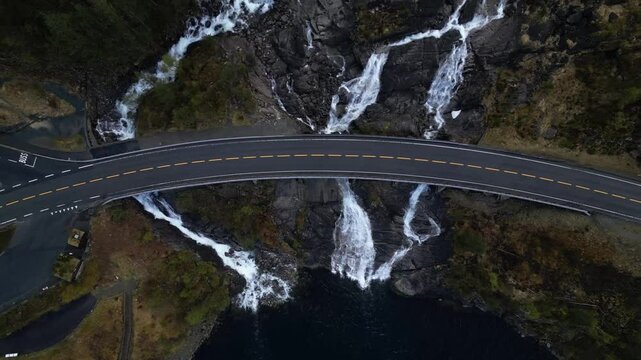 Drone top view of the stunning Langfoss waterfall in the fjord with a height of 600 meters. The waterfall is visible from the road.