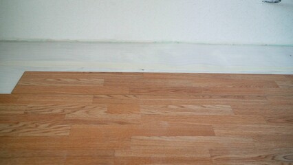 Several of laminated panels the color of the wood. Installation of laminate under a tree. Parquet in oak color. 