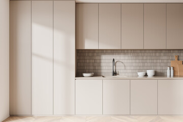 Beige modern home kitchen interior with cooking cabinet and kitchenware