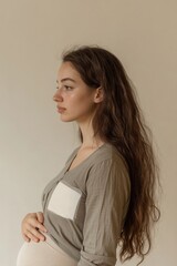 Fototapeta premium A pregnant woman with long brown hair sitting comfortably