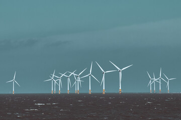 Offshore wind turbines farm in the ocean. Offshore wind turbines standing in the sea. Wind turbine...