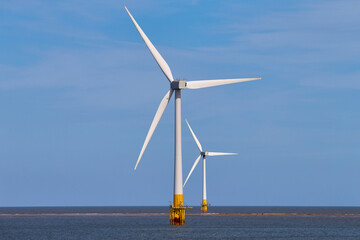 Windmill turbines at sea generate green energy. 