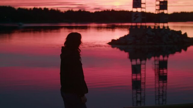 Silhouette of Woman Walking Next to Lake in Beautiful Sunset, Peaceful Stroll in Pink Sky