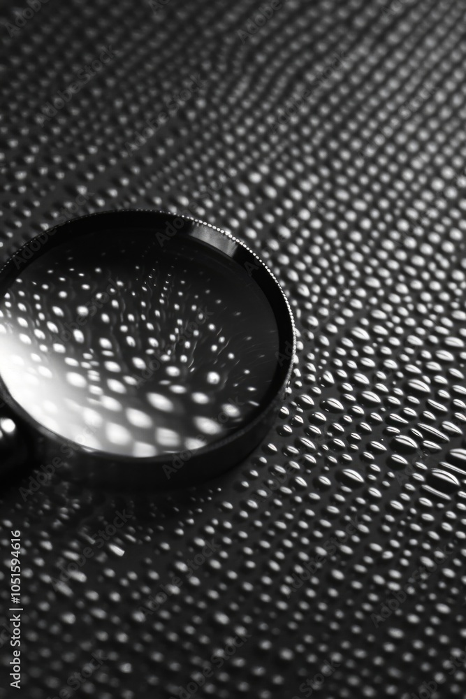 Poster a close-up shot of a magnifying glass sitting on a table, ideal for use in illustrations or graphics