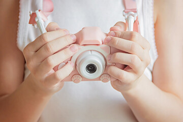 A child takes pictures with a camera. A photo card in the hands of a child