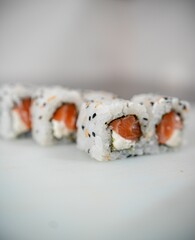 Close-up of sushi rolls with salmon and sesame seeds.