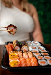 Assorted sushi rolls with chopsticks.