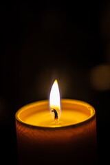 Close-up of a single candle burning in the dark. christmas, hope, beginning, meditation, relaxation, healing, tranquility, celebration background.