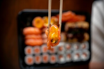 Chopsticks holding sushi close-up