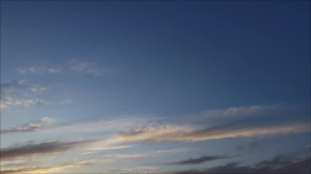Nubes cirros anaranjadas cambiando a un color ceniza