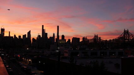 New York City Manhattan skyline cityscape. Rooftop in Queens, Midtown buildings, Queensboro Bridge. Sunset pink purple sky from roof in Long Island. Skyscrapers silhouette, high-rise architecture, NYC © Dogora Sun