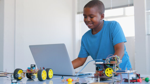 Male Student Building And Programming Robot Vehicle In After School Computer Coding Class 