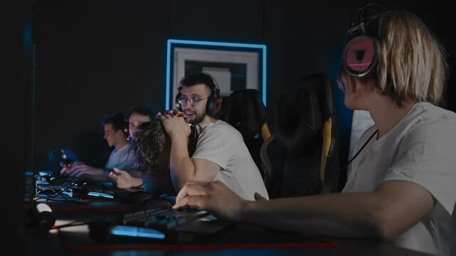 Player choked round in video game, gamers lose map defeat. Team lost match due to mistake of teammate, noob threw game. Five men play multiplayer online strategy in computer club. First-person shooter