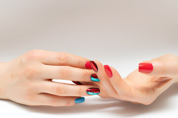 bright red blue manicure with shiny foil on short nails close-up on grey background	
