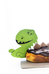 Dinosaur-Shaped Orange Cake with Chocolate Ganache on White Background with Text Space
