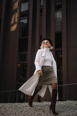 Stylish woman walking confidently in urban setting wearing modern fashion