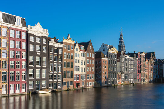 Dancing houses at Damrak and tower of Oude Kerk Amsterdam Church, Amsterdam, The Netherlands, Europe