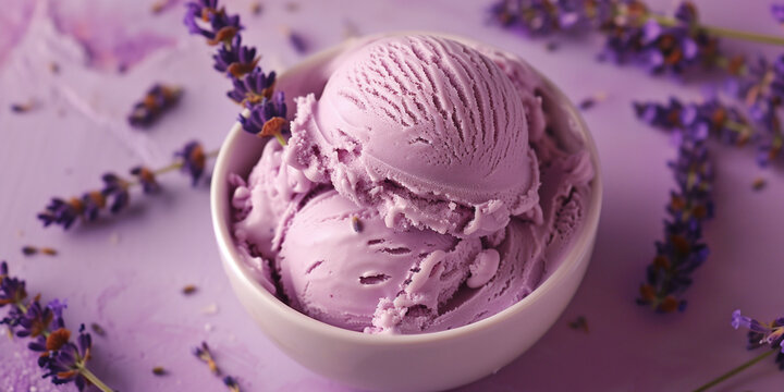 Texture closeup of scoops of lavender ice cream in a bowl, set against a pastel pink purple background, garnished with delicate edible lavender flowers